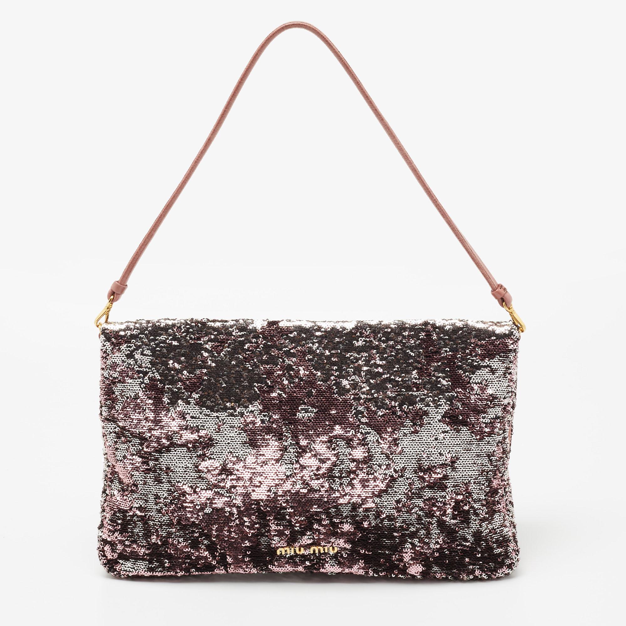 This Miu Miu clutch is much sought after by the fashion conscious. A splendid complement to your party dress will be this shimmering clutch in metallic tones. Made from sequins and having a well-sized fabric interior, the chain clutch is a