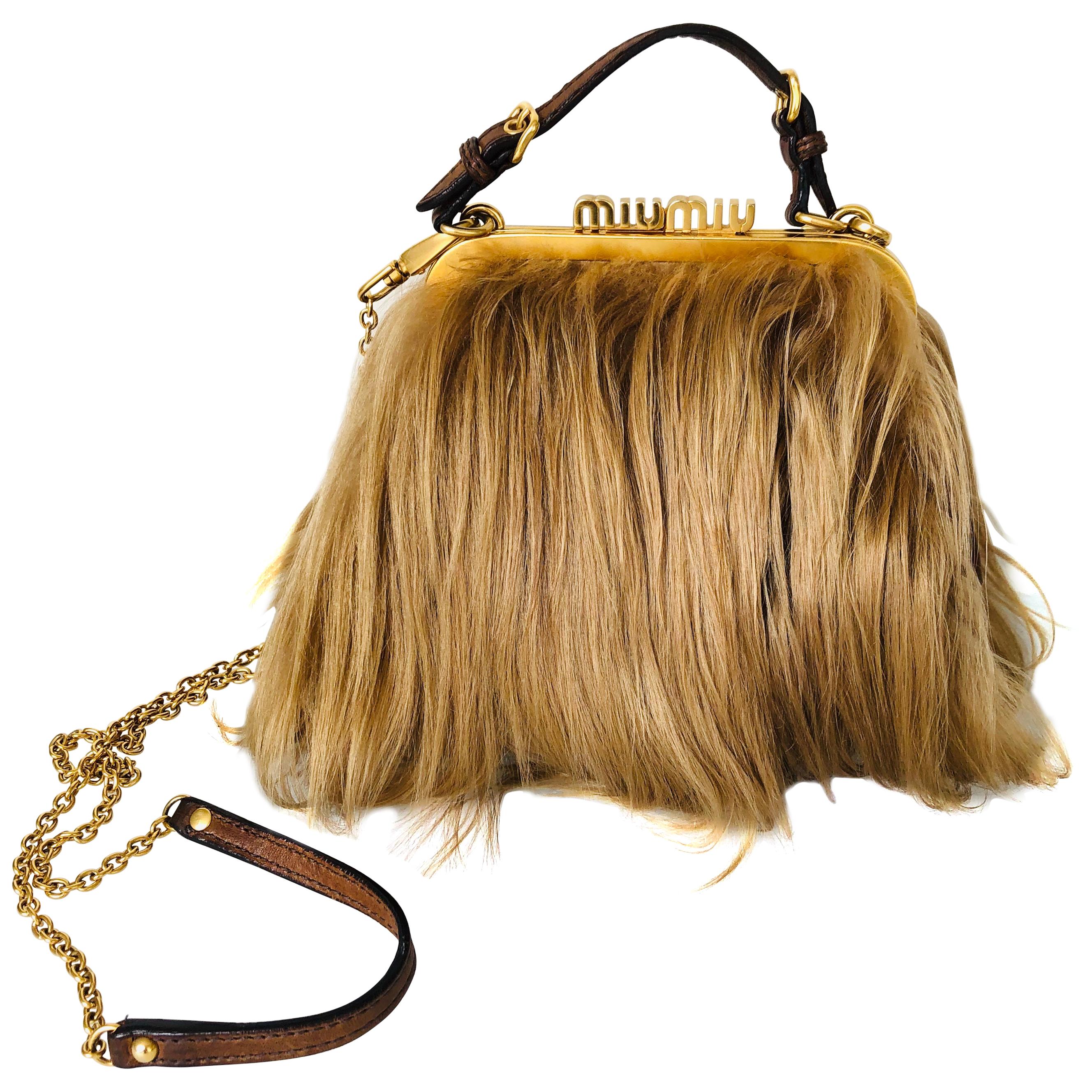 Stunning MIU MIU Mongolian goat fur bag featuring detachable shoulder strap, gold chain with leather details, long goat hair and leather trimmings, top clutch closure, interior in brown cotton, gold hardware, Made in Italy.

Serial number: