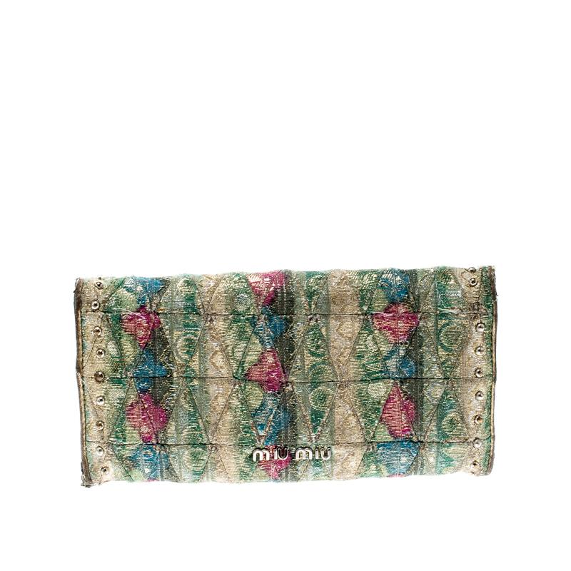 Bring out the elegant lady in you with this multicolored clutch from Miu Miu! Crafted in jacquard fabric, the exterior is adorned with silver-tone studs and the front has a twist lock closure with the brand name engraved on it. The leather and