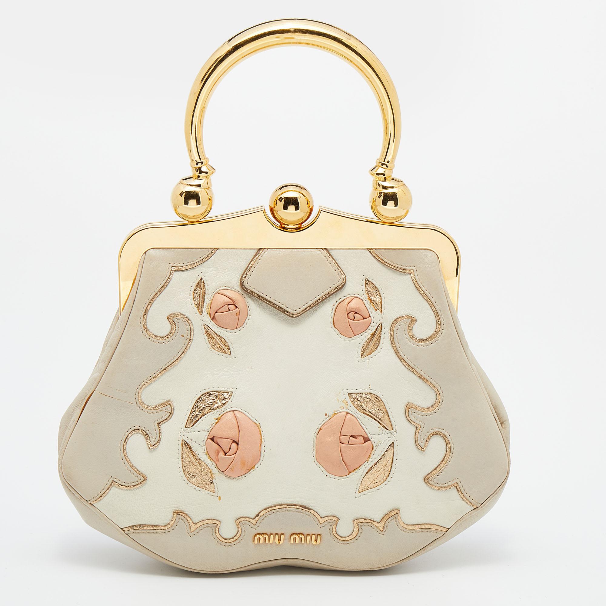 The splendid design of this Miu Miu bag makes it distinct and eye-catching. Created from leather, it is complemented with a lock closure on the top frame, brand detailing at the back, and a single handle. The satin-lined interior of this multicolor