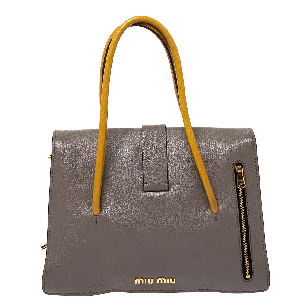 Diese Miu Miu Tasche in einem atemberaubenden Mix aus Senf- und Grautönen verwandelt Ihr Outfit in eine Kombination aus Klassik und Moderne. Sie ist aus Madras-Leder gefertigt und mit goldfarbenen Beschlägen:: einem Lederanhänger an der Seite und