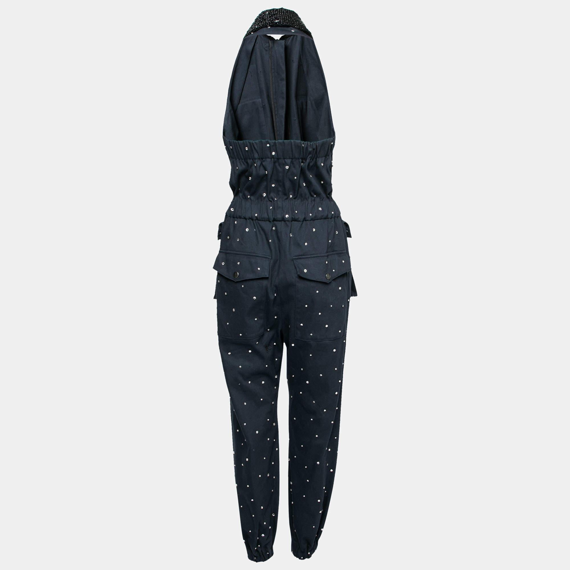 This Miu Miu jumpsuit will be an elegant addition to your closet. Crafted skillfully from cotton and featuring embellishments and bead embroidery, the halter neck creation has a navy blue shade that will match well with minimal accessories. It is