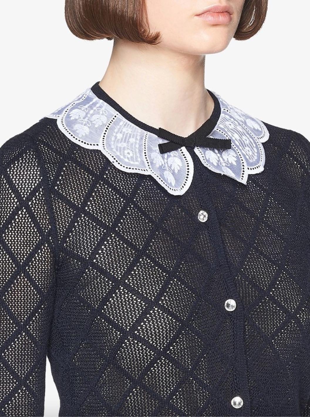 Diese elegante Strickjacke von Miu Miu besticht durch ihr einzigartiges Steppmuster aus navyblauem Kaschmir und Seidenstrick. Das besondere Merkmal ist der aufwendig verzierte Blütenkragen mit zarten Spitzendetails, der dem Kleidungsstück einen