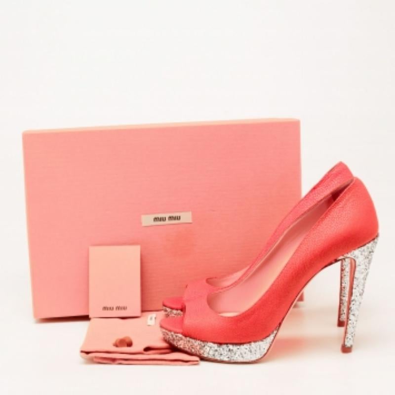 Miu Miu brings an element of class to your closet with these stunning pumps. They are created using neon pink patent leather and glitter on the exterior. They showcase peep toes, slim heels, and a slip-on closure. Make a fashion statement by wearing