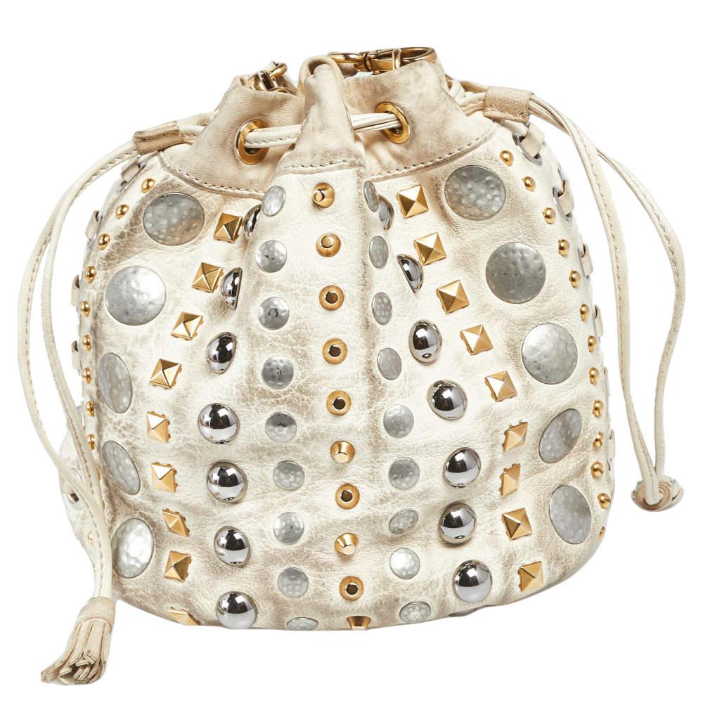 This wonderful Miu Miu design is made from leather and enhanced with studs. The bag has a bucket shape with a drawstring closure that secures the satin interior. Complete with a shoulder strap, it is an apt accessory to carry your everyday