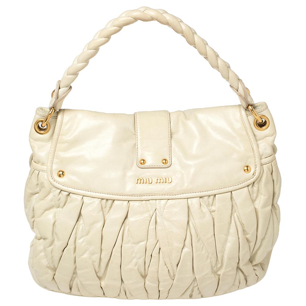 This chic and feminine Coffer hobo is from Miu Miu. The bag is crafted from off-white leather carrying the signature matelassé pattern and features a flap that opens up to a fabric-lined interior sized to fit your daily essentials. The hobo is