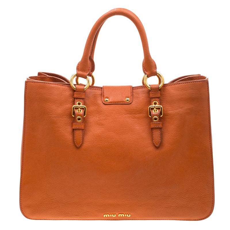 This elegant Madras tote from Miu Miu will make a valuable addition to your collection. The tote is crafted from orange leather and features a chic silhouette. It has dual handles, a shoulder strap and a suede-lined interior that is spacious enough