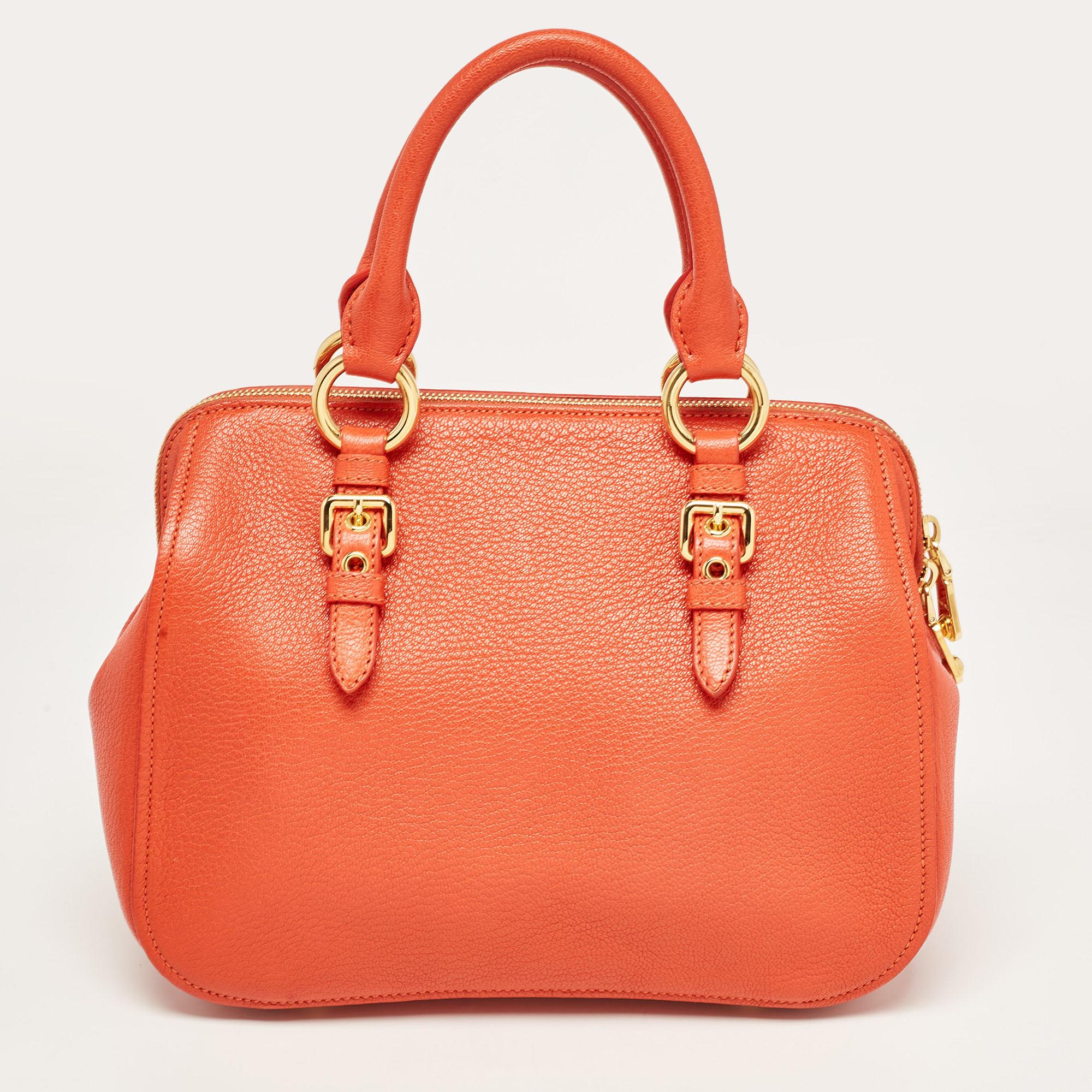 Simple and classy, style your outfit with this orange bag from Miu Miu. Crafted from leather, the bag is held by dual handles and a shoulder strap. The zip closure opens to a satin-lined interior that can hold all your essentials in one go. it is