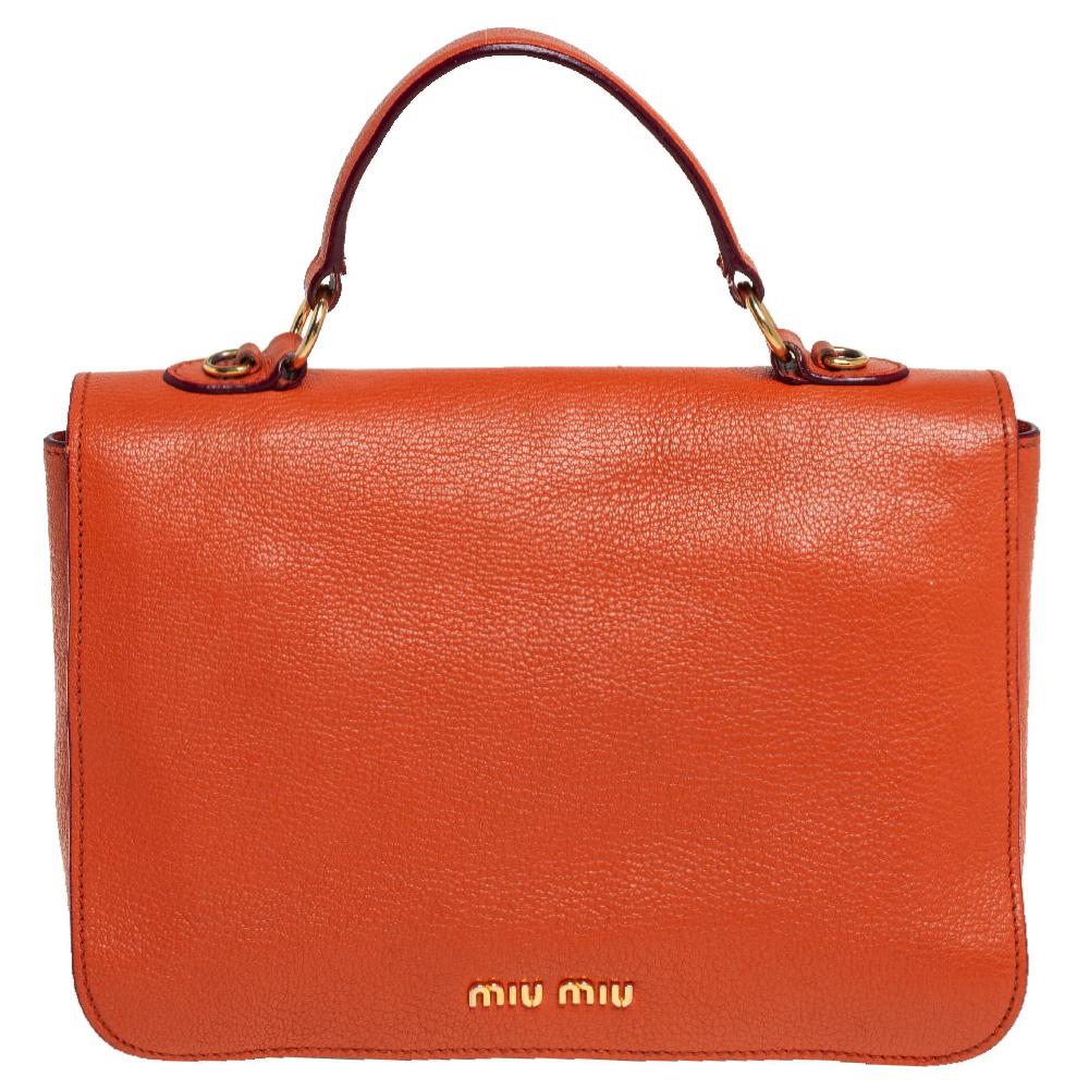 A chic bag for you to step out in style and win compliments! This orange bag from Miu Miu comes crafted from Madras leather and features a front gold-tone lock detailed strap. It has a top handle and a detachable shoulder strap and opens to a
