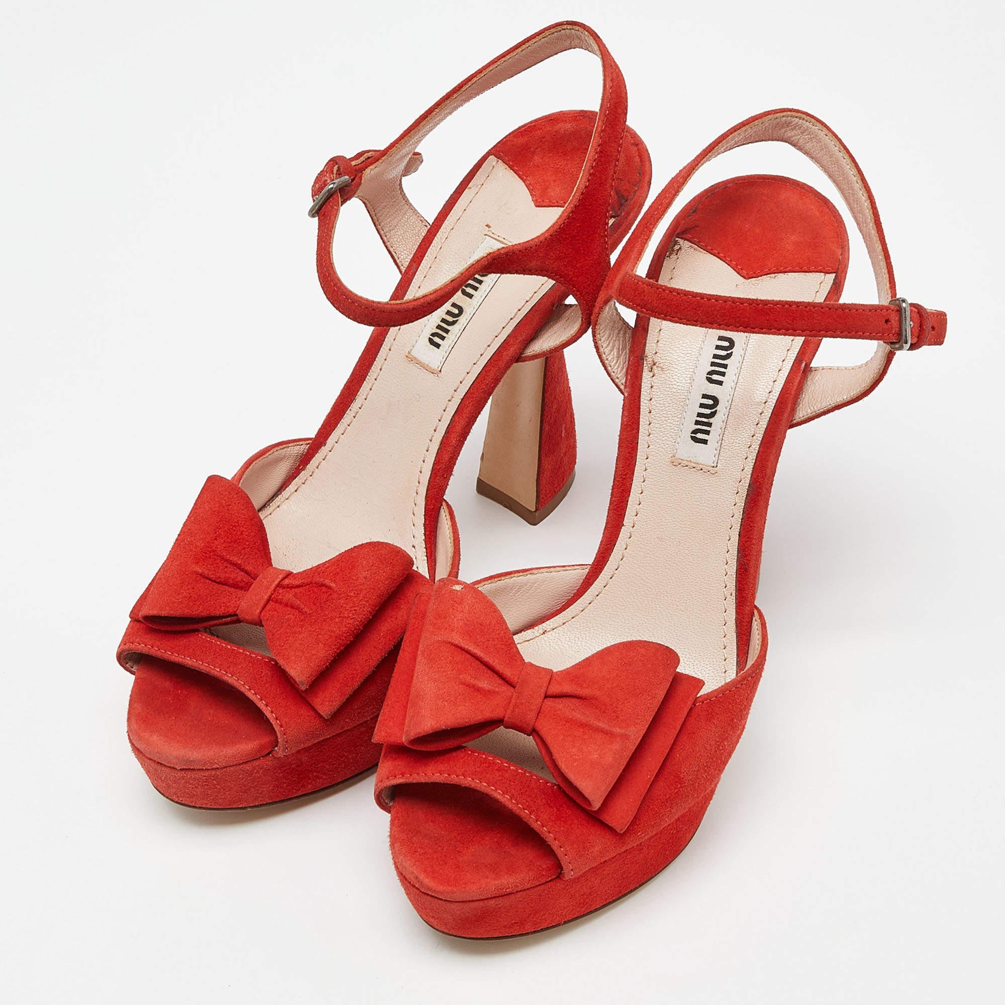 Apportez un style signature et une beauté iconique à votre garde-robe avec ces sandales de la maison Miu Miu. Elles sont réalisées en daim orange et leur beauté est soulignée par des nœuds. Ils sont dotés de talons de 12 cm, de brides à la cheville