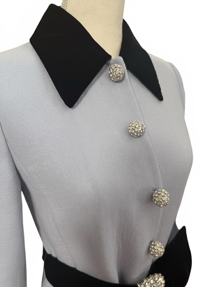 Questo cappotto con cintura impreziosita in misto lana blu chiaro e nero di Miu Miu presenta un colletto a punta a contrasto, una chiusura frontale con bottoni impreziositi, maniche lunghe, polsini con bottoni, una cintura a contrasto in vita con
