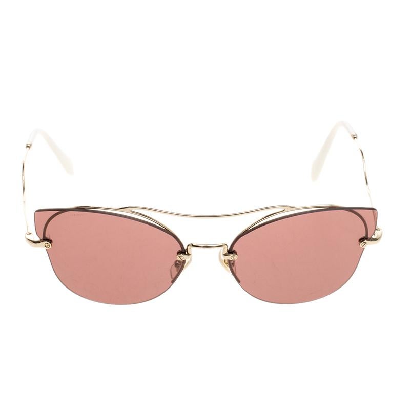 Designed in a glamorous cat eye shape, these Miu Miu aviator sunglasses feature an extended lens design without any frame. With a gold tone wavy top bridge and half rims, these sunglasses are completed with gold tone arms and a violet coloured large