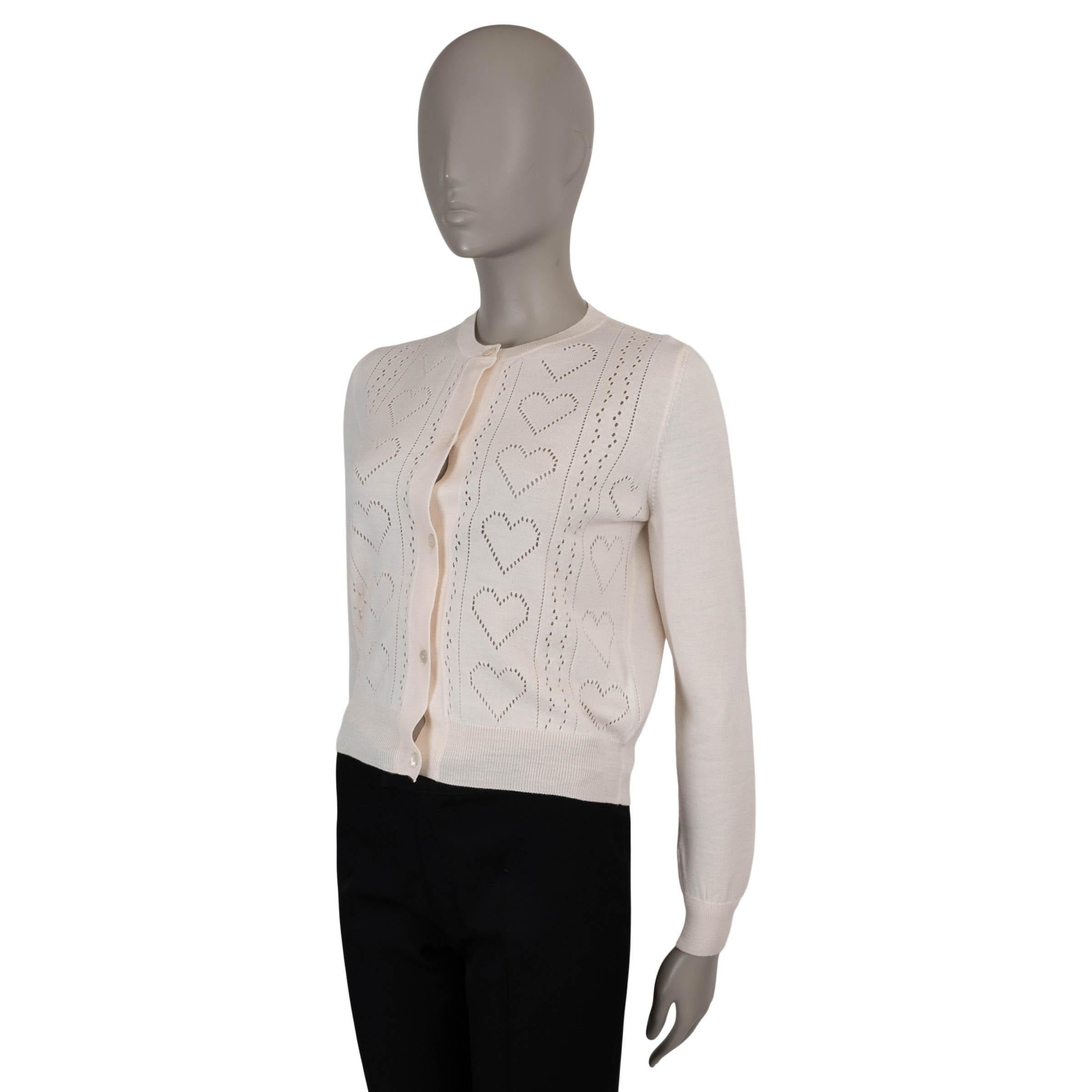 Ce cardigan Miu Miu 100% authentique en laine (70%) et cachemire (30% - veuillez noter que l'étiquette de contenu est manquante) rose pâle pointelle est une pièce délicate et féminine. Doté d'un motif de cœur complexe, il présente une silhouette