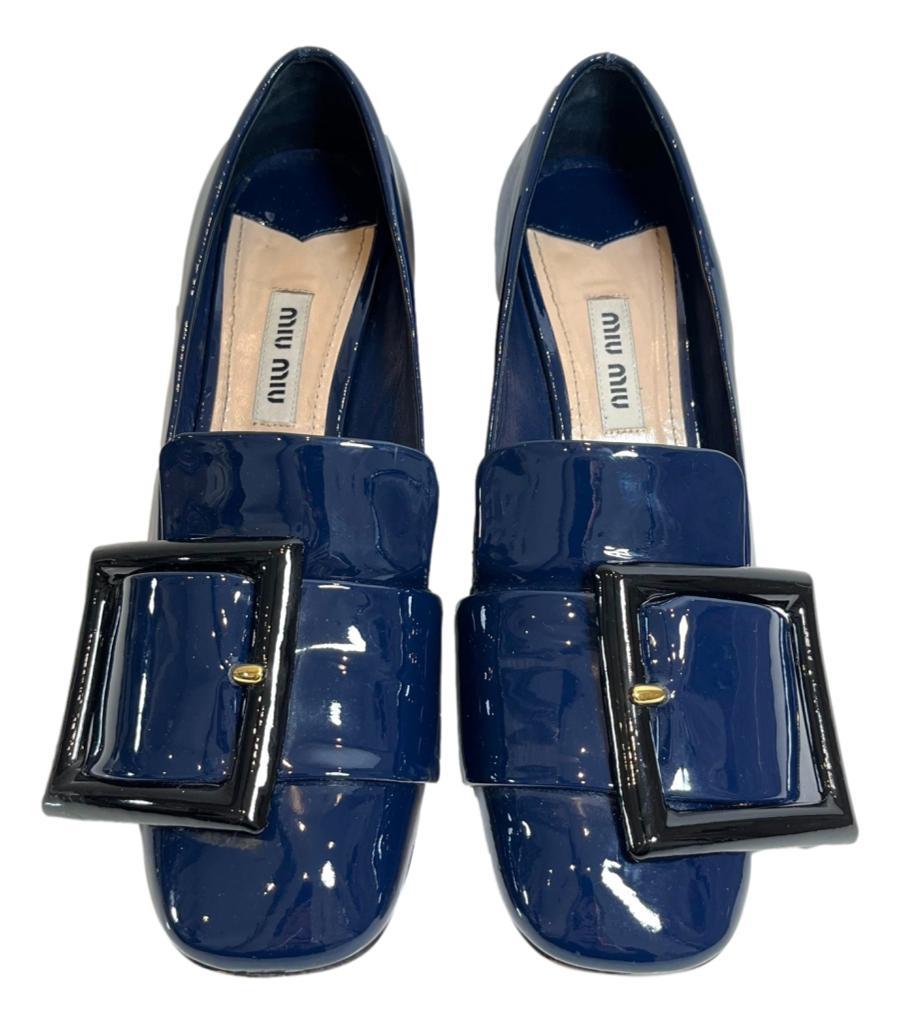 Miu Miu Patent Leather Buckle Detailed Pumps

Indigo blue loafers-inspired heels designed with oversized buckled strap detail to the vamp.

Featuring curved block heel and square toe.

Size – 35.5

Condition – Good (Scratches to the leather, wear to