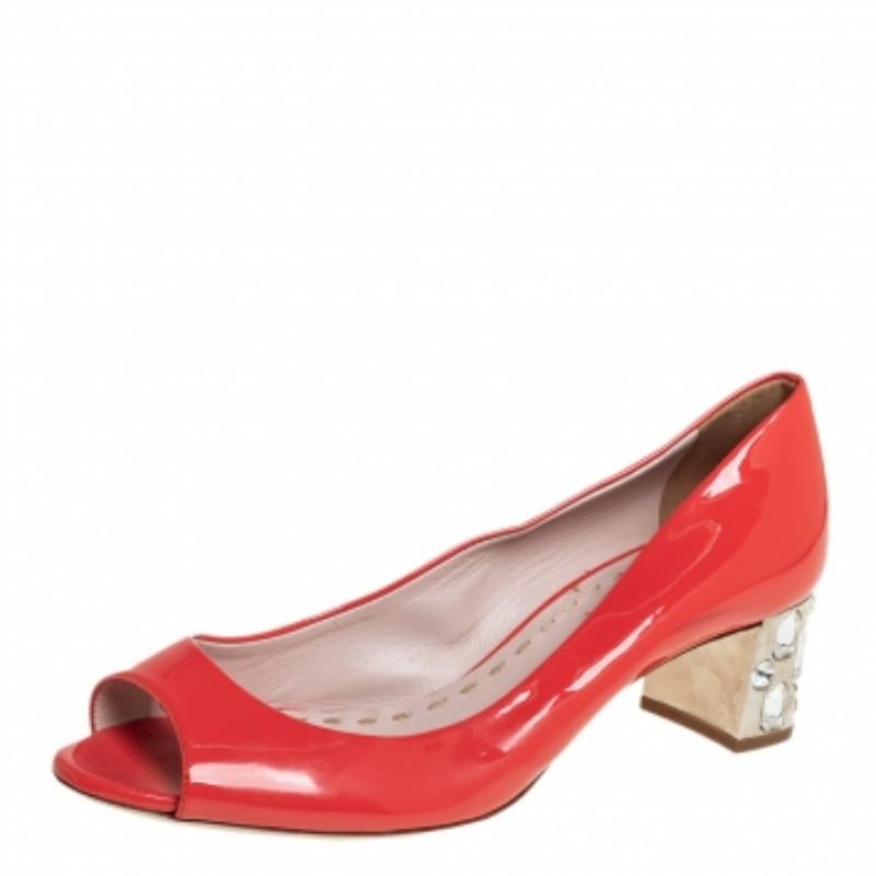 Miu Miu brings to you these lovely pumps to complement your fashionable ensembles. The orange peep-toe pumps are crafted from patent leather and feature crystal-embellished block heels.