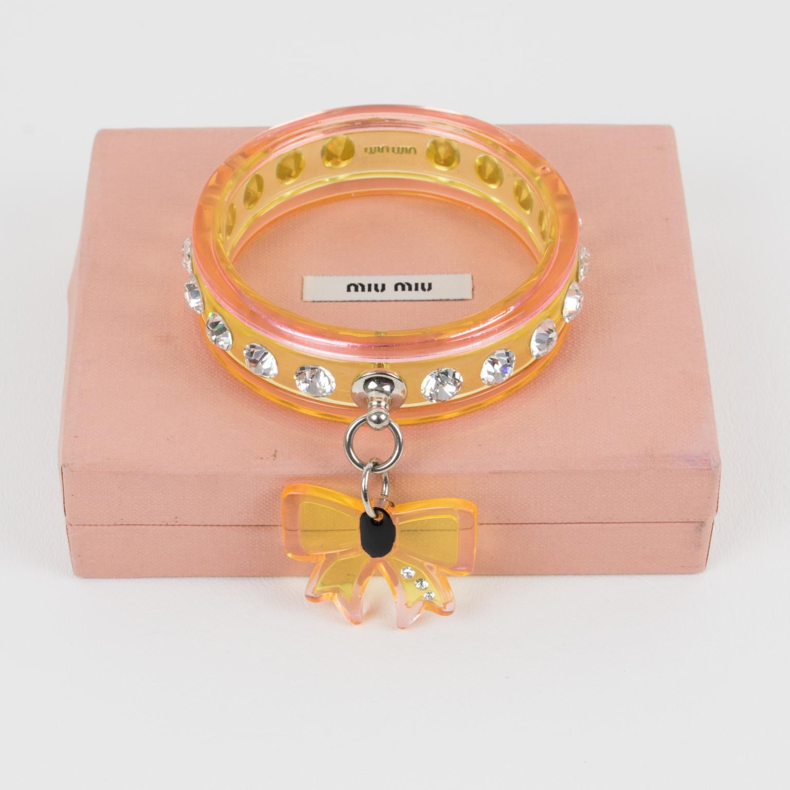 So cute Miu Miu acrylic bracelet bangle. Carved shape in transparent acrylic or Lucite with crystal rhinestones all around. Compliment with bow charm on the side in same color and material. Assorted colors of powder pink and light yellow. Chromed