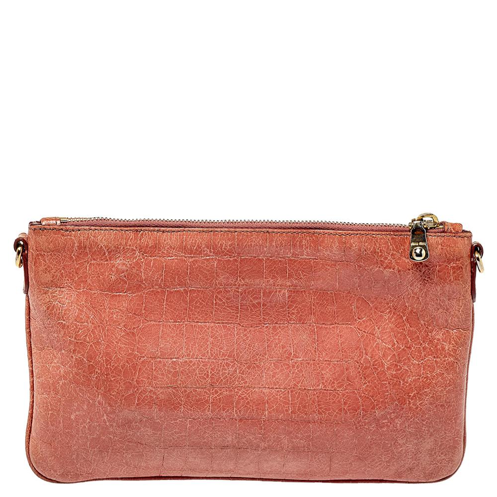 Here's a bag from Miu Miu that is both stylish and functional! Crafted from pink croc-embossed leather, the crossbody bag is divided into two sizeable fabric-lined compartments that make it easy to organize your daily essentials. It has zip