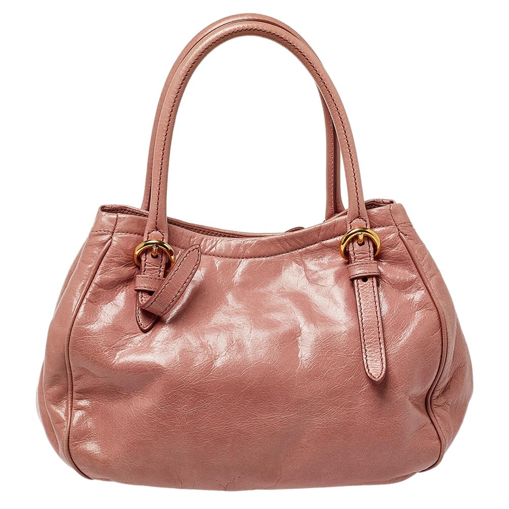 This Miu Miu handbag promises to help you stay stylish from day to night and weekday to weekend. Crafted from pink leather, this bag is equipped with two handles and a detachable shoulder strap and flaunts a bow detailing on the