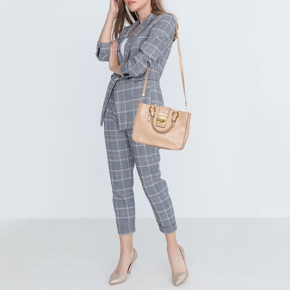You'll love carrying this Madras bag by Miu Miu. Made from pink leather, this women's tote features dual handles supported with gold-tone rings, a flap with brand detailed push-lock closure, and a detachable shoulder strap. The interior is lined