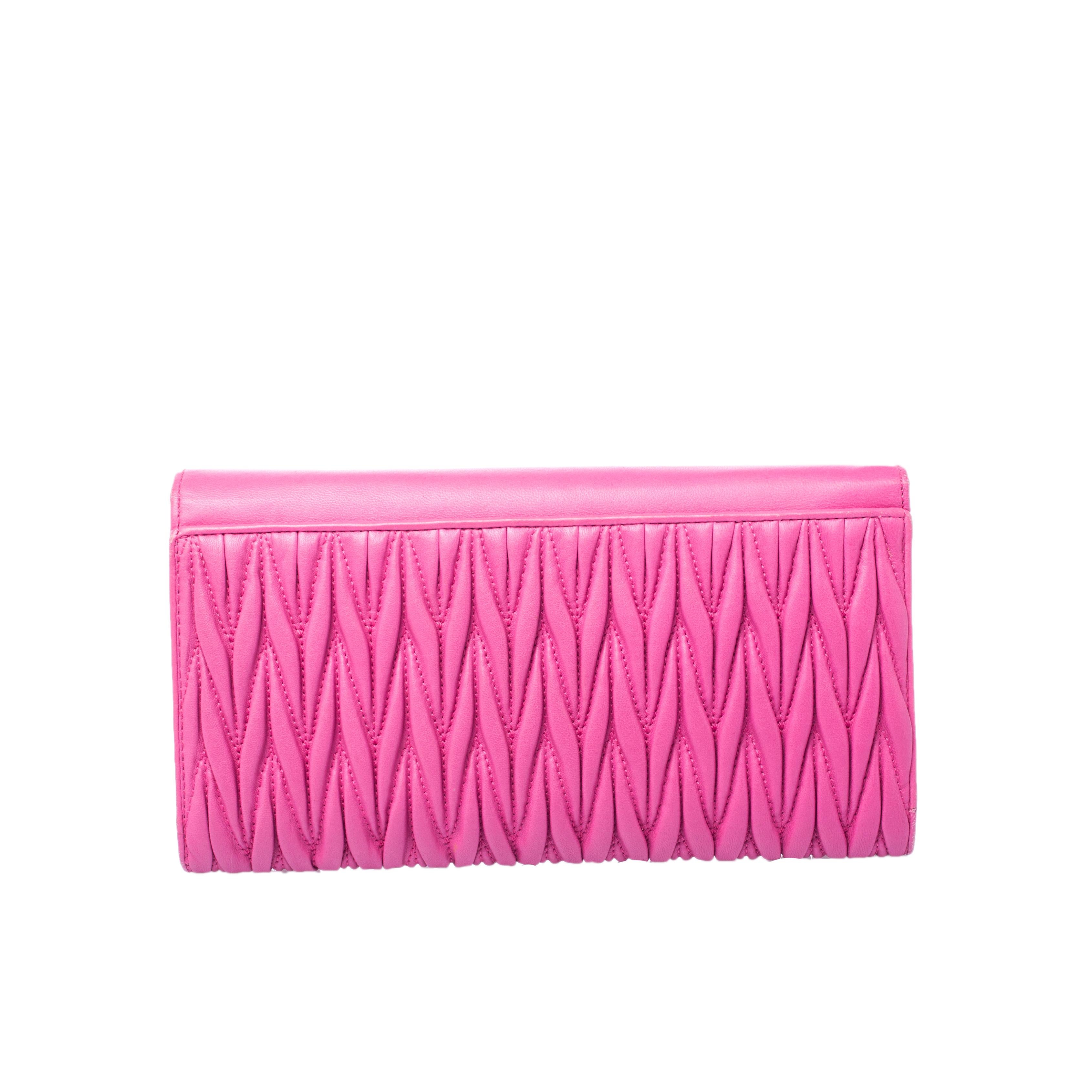 With classic matelassé leather, this clutch from Miu Miu comes in a structured shape flaunting a pretty pink hue. The smooth front flap opens to a leather-lined interiors housing multiple card slots and open compartments. The signature brand name