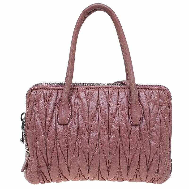 Add a lively dose of pink to your wardrobe with this Matelasse Leather bag by Miu Miu. Its ruched pink leather exterior is accented with a simple silver Miu Miu label, rolled leather handles and a removable shoulder strap. The large interior is