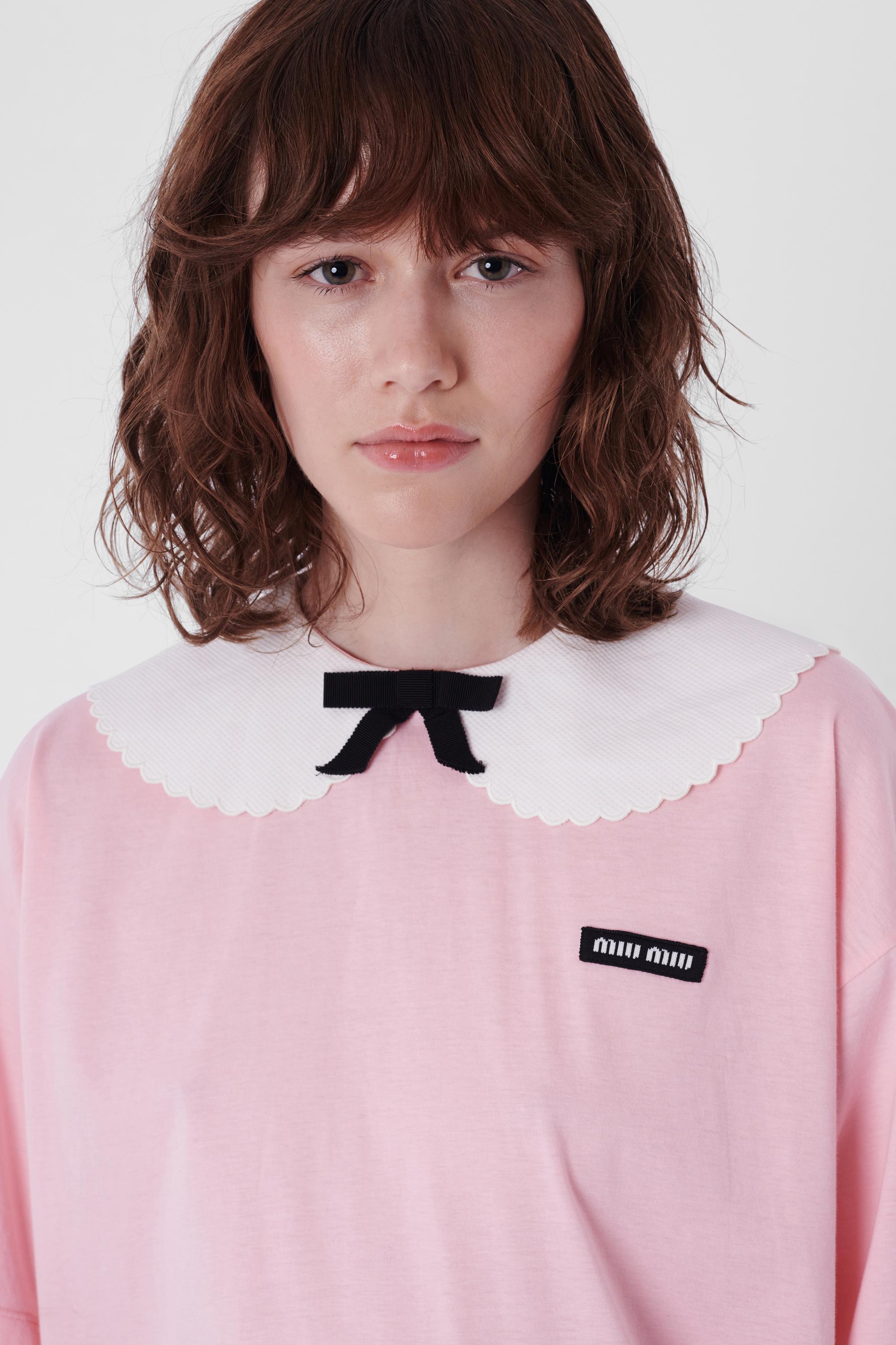 Nordic Poetry is excited to present this Miu Miu pink t-shirt. Features white scallop edged collar, black ribbon bow, Miu Miu tag motif and button back closure. Pre-loved, in excellent condition - never been worn. Authenticity Guaranteed.

Label
