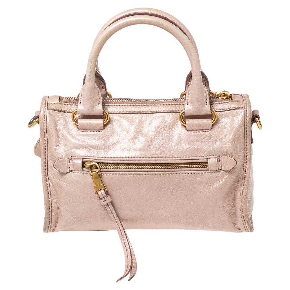 This opulent and multipurpose Bauletto satchel from Miu Miu would go perfectly for any of your occasions. Crafted from pink Vitello Shine leather, the bag is held by two handles and a shoulder strap. The zip-top closure opens to a fabric-lined