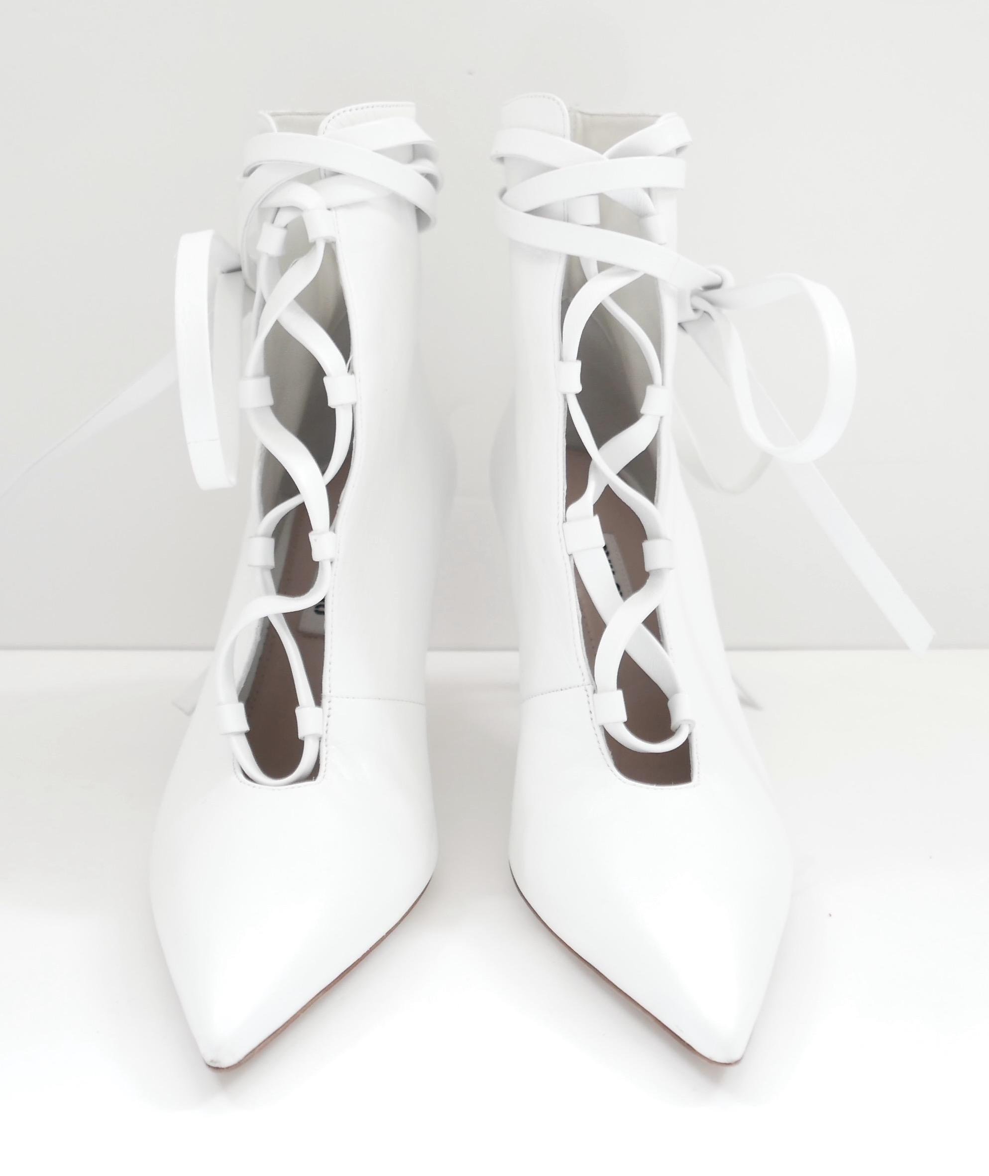 Divertidos botines blancos atados de Miu Miu de la colección Pre-Fall 2018 - Look 7. Comprados por 775 € y usados una vez. Viene con bolsa guardapolvo. Fabricados en piel blanca brillante, tienen la parte delantera con cordones de piel inspirados en