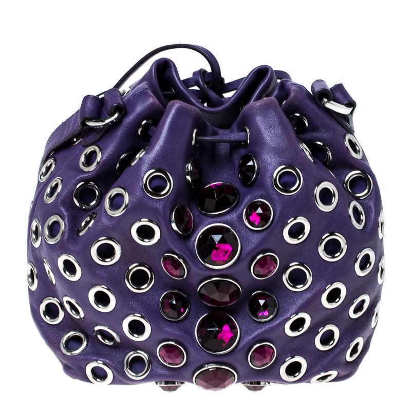 This Miu Miu bag is crafted in quality leather and covered in eyelets and crystals. With a drawstring closure, the purple-coloured bucket bag secures your essentials within the leather interior. The easily adjustable shoulder strap makes it a