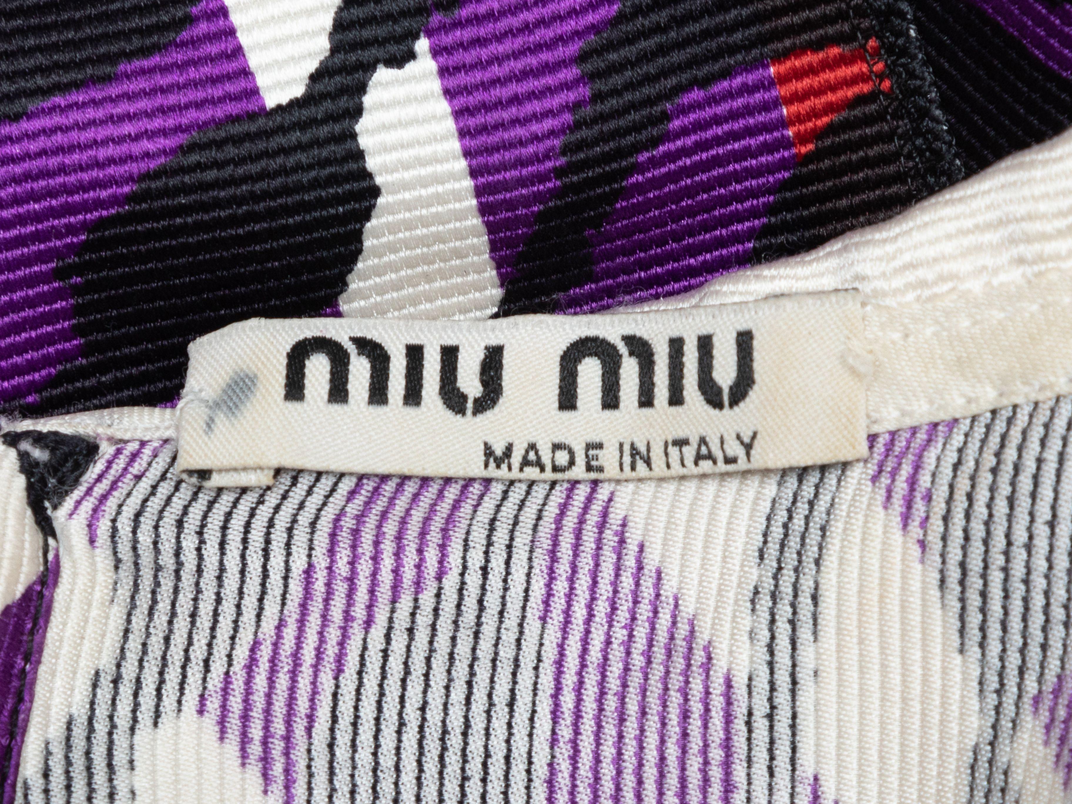 Product Details: Purple and multicolor printed dress by Miu Miu. Peter Pan collar. Three-quarter sleeves. Button closure at nape. 30