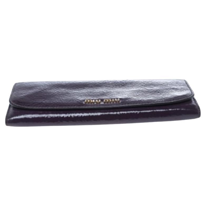 Esta cartera de Miu Miu es una creación que una fashionista como tú debe tener. Está maravillosamente confeccionado en charol y luce un elegante exterior morado. También viene equipada con una solapa que se abre para revelar un interior de nailon