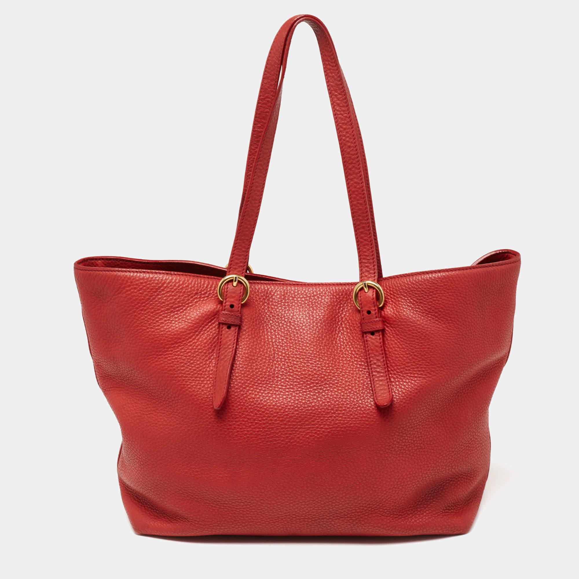 You don’t have to worry about things missing or falling with this shopper tote from Miu Miu. Made from red leather, this tote features two attached handles and a removable shoulder strap. The satin-lined interior is sized to carry your belongings