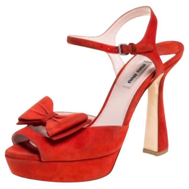 Miu Miu opts for elegance glamour with these stunning red sandals. They’re made from soft suede in a red hue with smooth leather soles and lining, set on statement platforms and block heels with ankle straps. These sandals are adorned with dainty