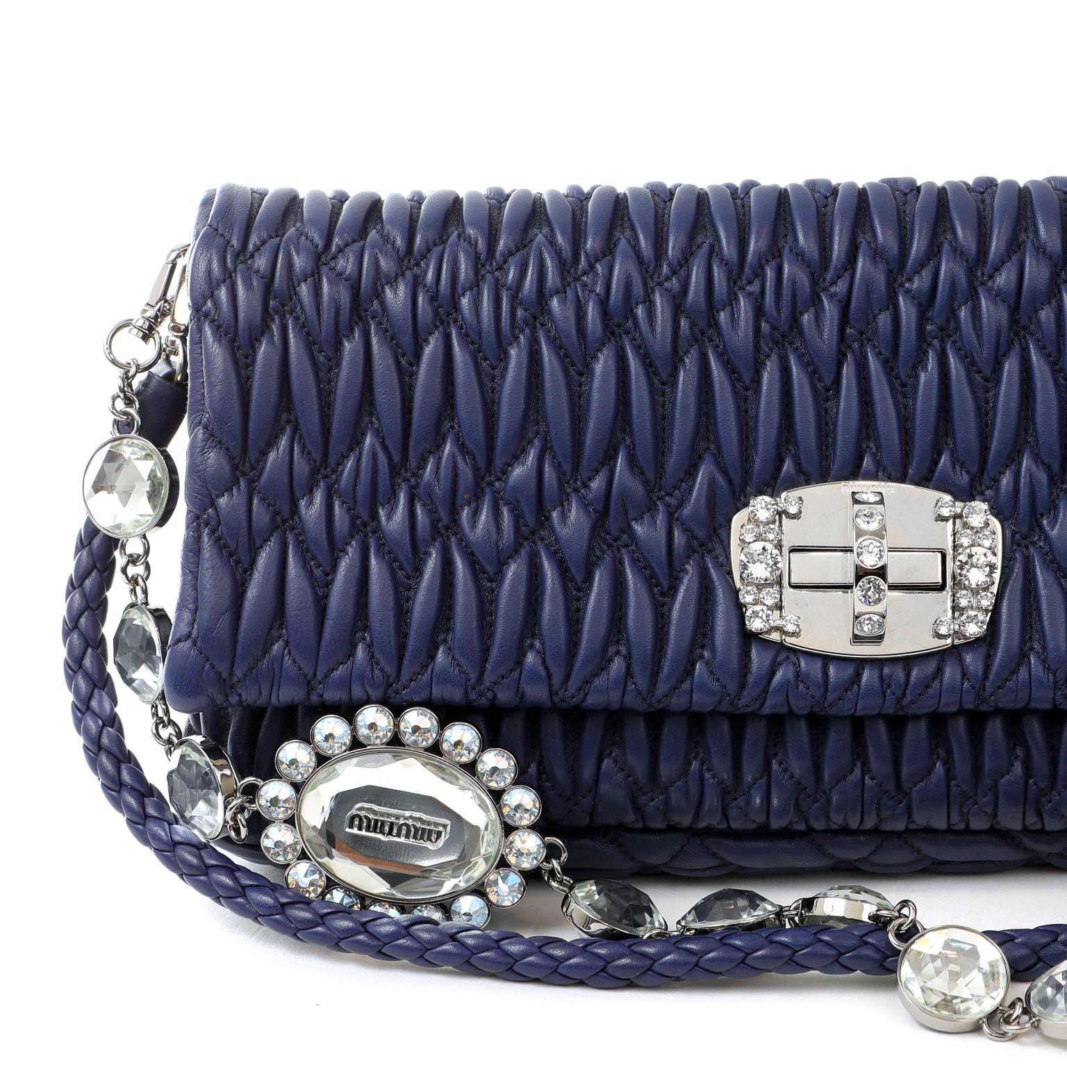 This authentic Miu Miu Royal Blue Crystal Cloquè Small Bag is in pristine condition.  The iconic design features blue quilted Nappa leather and a crystal turn lock closure.  May be carried by the detachable leather strap or the decorative crystal