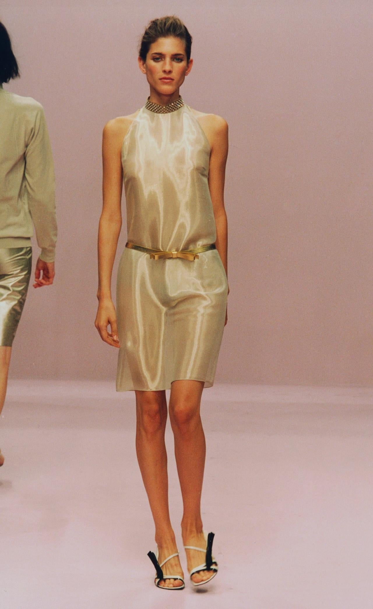 Debuttato come look di chiusura della passerella Primavera/Estate 2000 di Miuccia Prada, questo raro abito in seta cattura l'atmosfera elegante e futuristica che ha definito la collezione. Tagliato da una seta luminosa e senza peso in una morbida