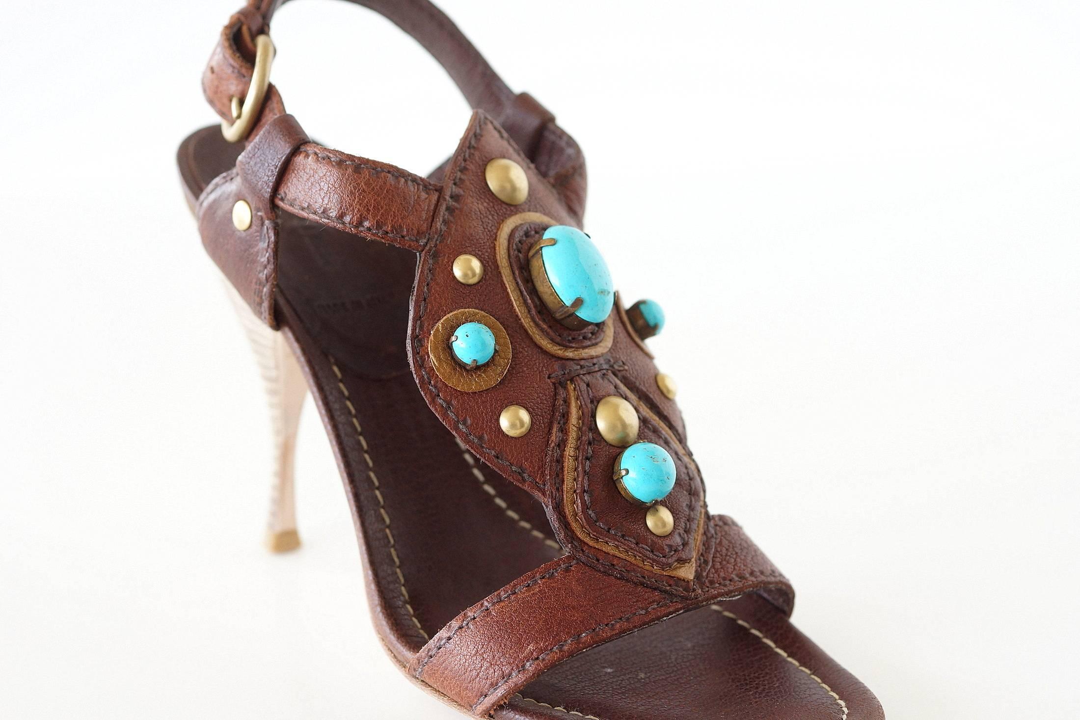 Guaranteed authentic Miu Miu shoe in rich brown Buffalo leather.
The top of the foot has fabulous leather work accentuated with turquoise stones and brass studs.
Bronzey gold leather trim around the turquoise stones.
Round brass buckle on the side