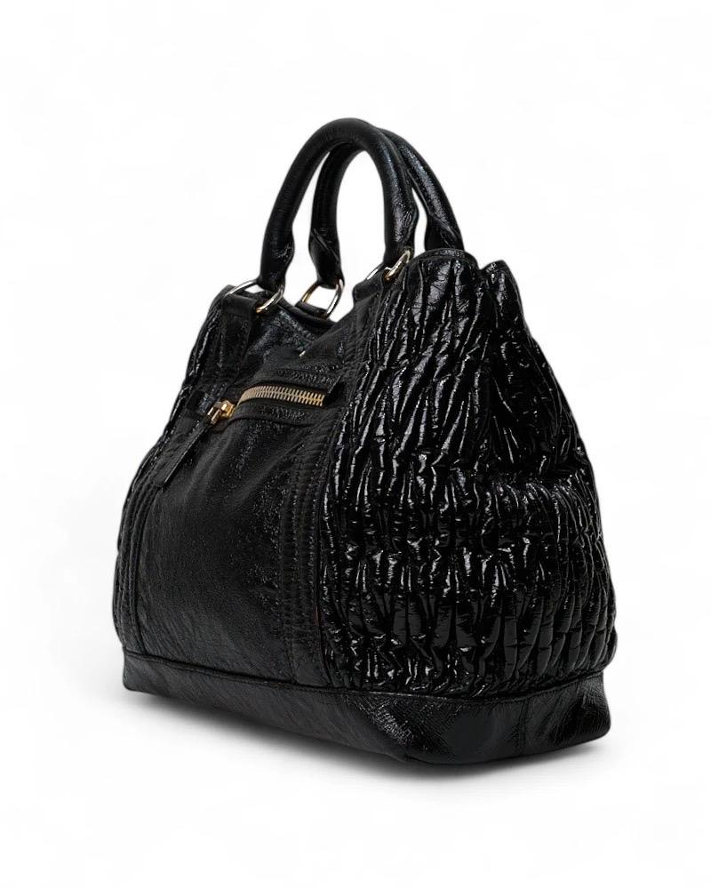 Borsa firmata Miu Miu, modello Shopper, realizzata in pelle groffata nera con hardwre dorata. Dotée d'une chiusura à fond calamiteux, internamente rivestita in tela tono su tono con comoda tasca, la borsa è abbastanza capiente. Muni d'une double