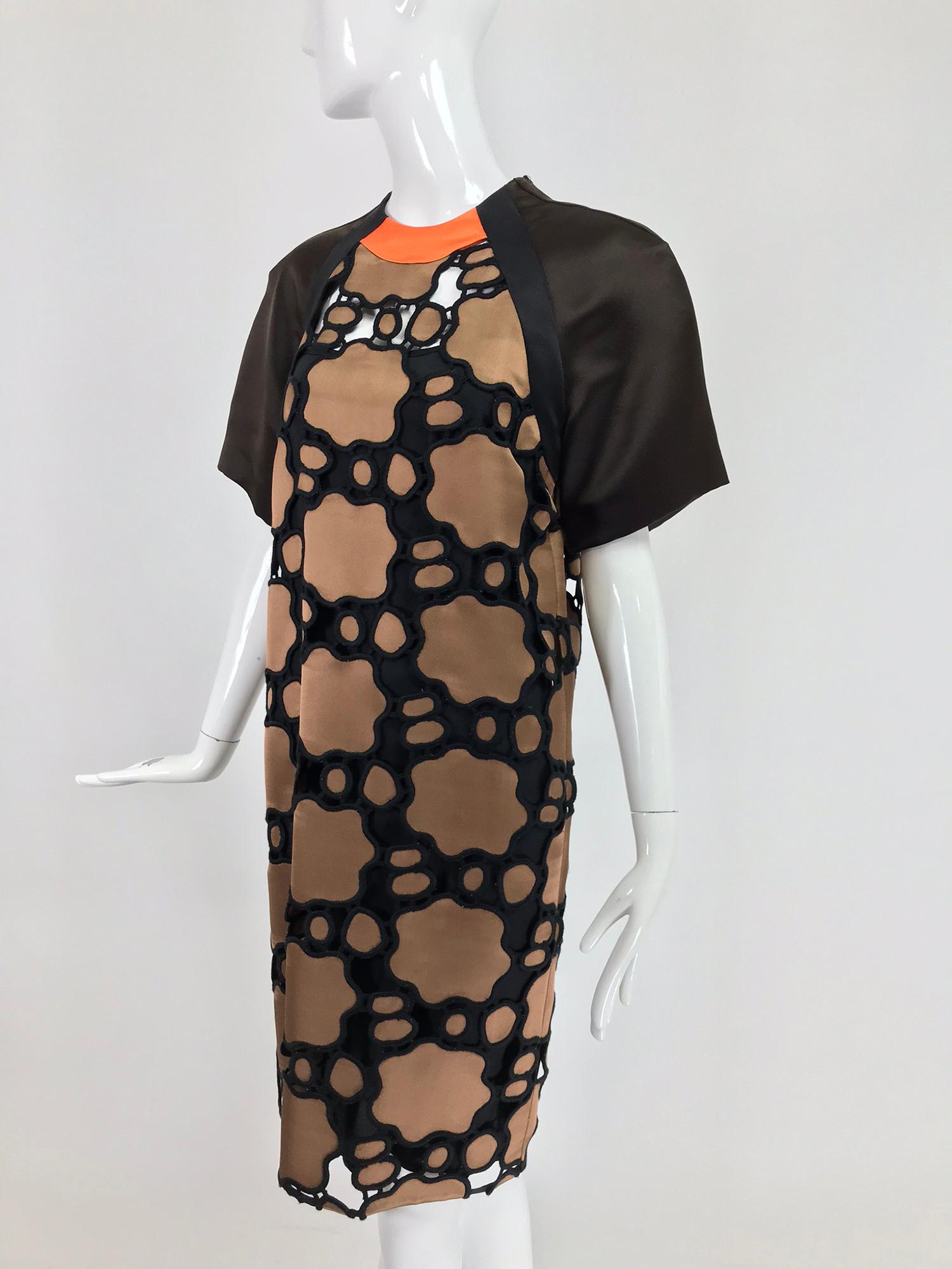 miu miu cut work day dress in brown and black with orange chain pattern. Jewel neck dress with raglan sleeves together with original black silk slip. Pull on dress has wide brown silk twill sleeves that are banded in black twill and an orange band