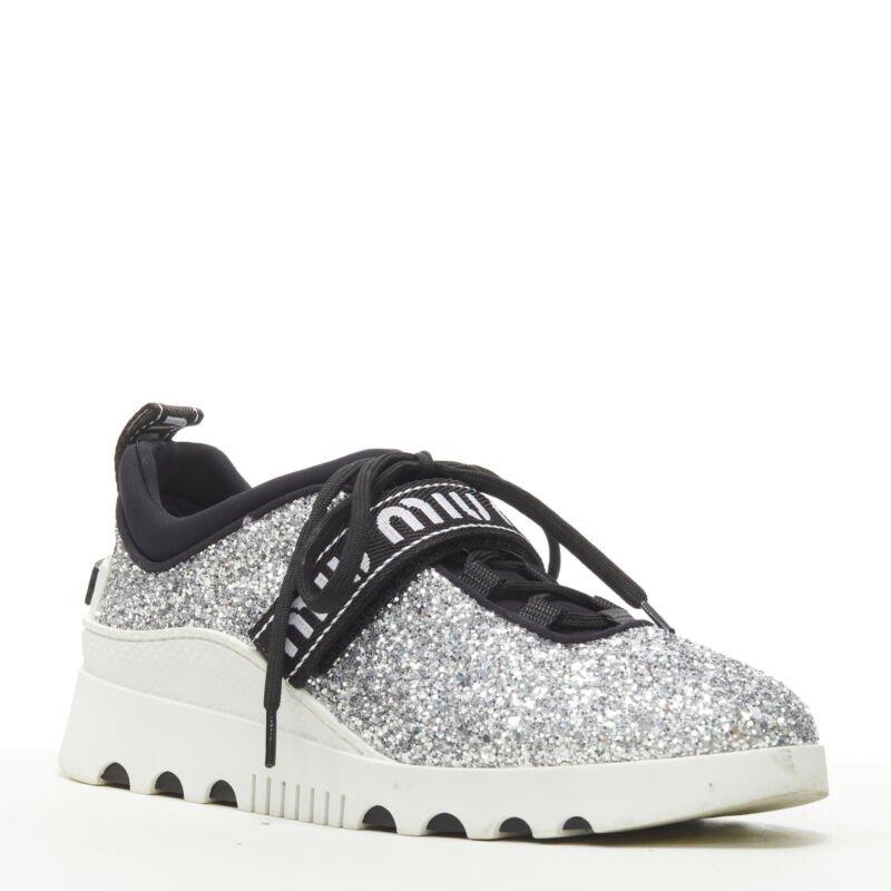 MIU MIU silver glitter logo strap low top runner sneaker EU36
Reference: ANWU/A00363
Brand: Miu Miu
Designer: Miuccia Prada
Material: Leather, Rubber
Color: Silver, White
Pattern: Logomania
Closure: Lace Up
Lining:  Fabric
Extra Details: Scuba