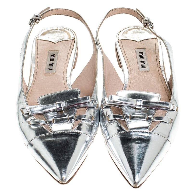 Create the most elegant looks with these Miu Miu slingback sandals. Designed in the chic and effortless silver patent leather, these sandals are further adorned with bows on the vamps and a sturdy sole that will offer you all-day comfort.

Includes: