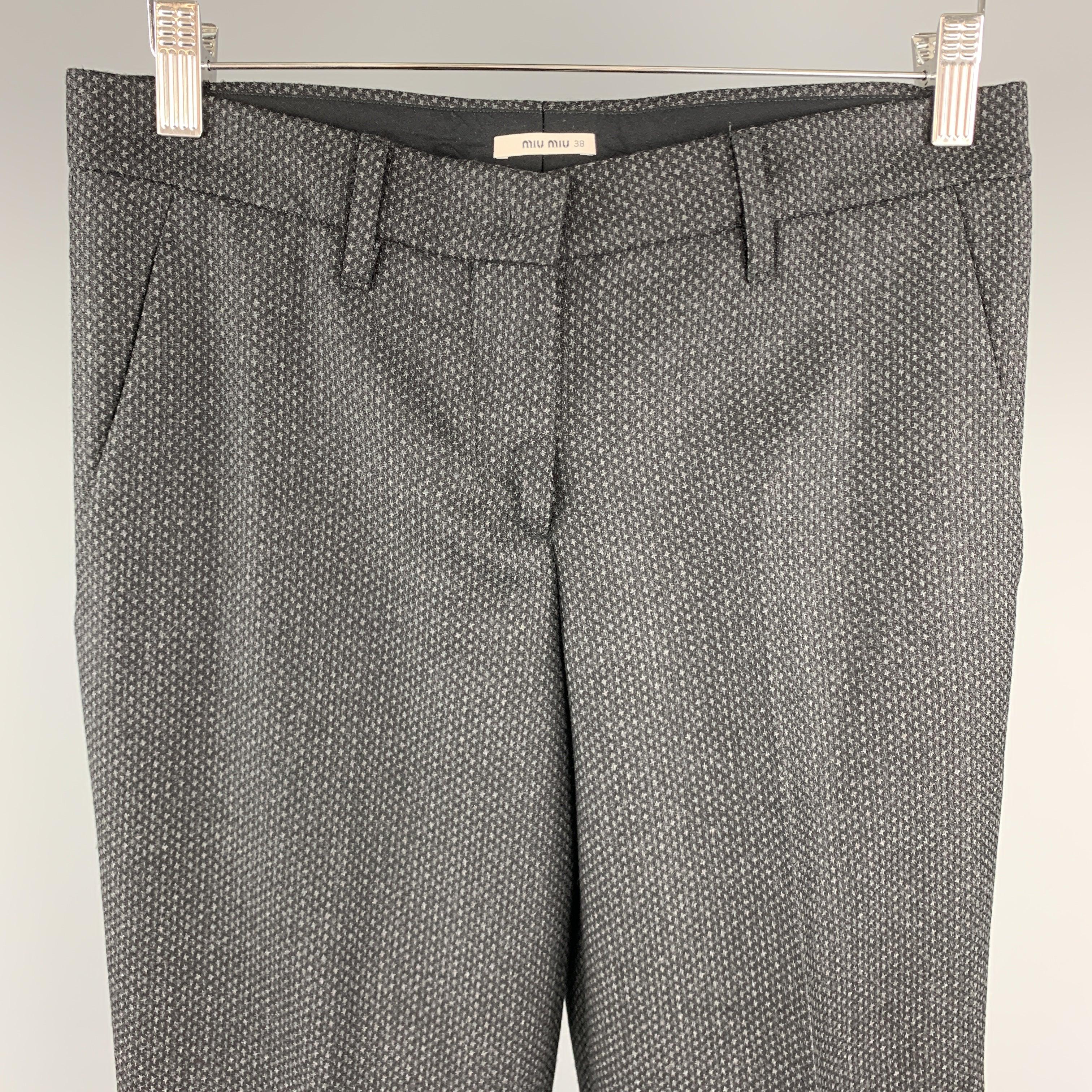 MIU MIU dress pants come in charcoal wool with an abstract houndstooth pattern wih a cropped tapered leg.
Excellent
Pre-Owned Condition. 

Marked:   IT 38 

Measurements: 
  Waist: 30 inches Rise:
9.5 inches Inseam: 25 inches 
  
  
 
Reference: