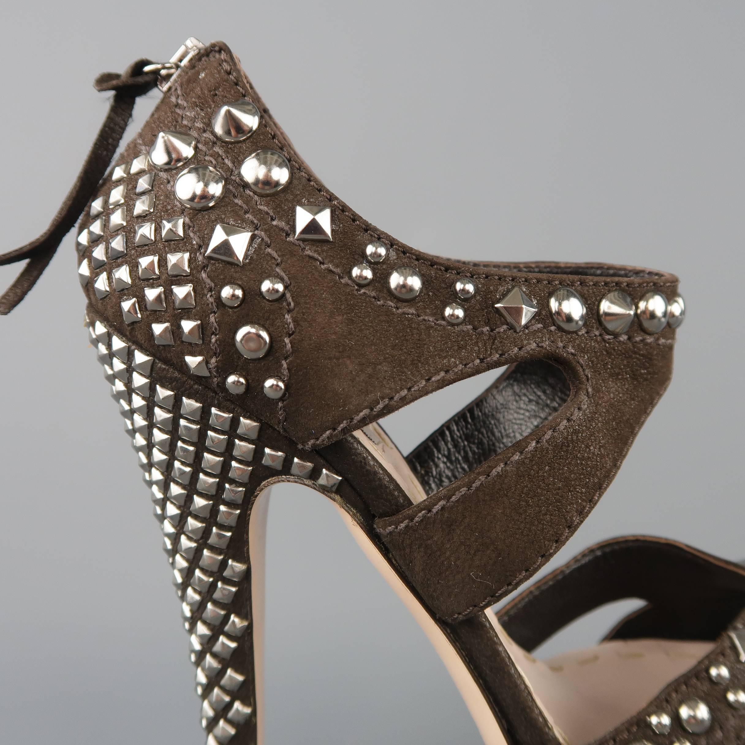 MIU MIU pumps come in chocolate brown suede covered in various silver tone studs with a thick ankle strap and covered heel and platform.  Made in Italy.
 
Excellent Pre-Owned Condition.
Marked: IT 35.5
 
Measurements:
 
Heel: 5.5 in.
Platform: 1.45