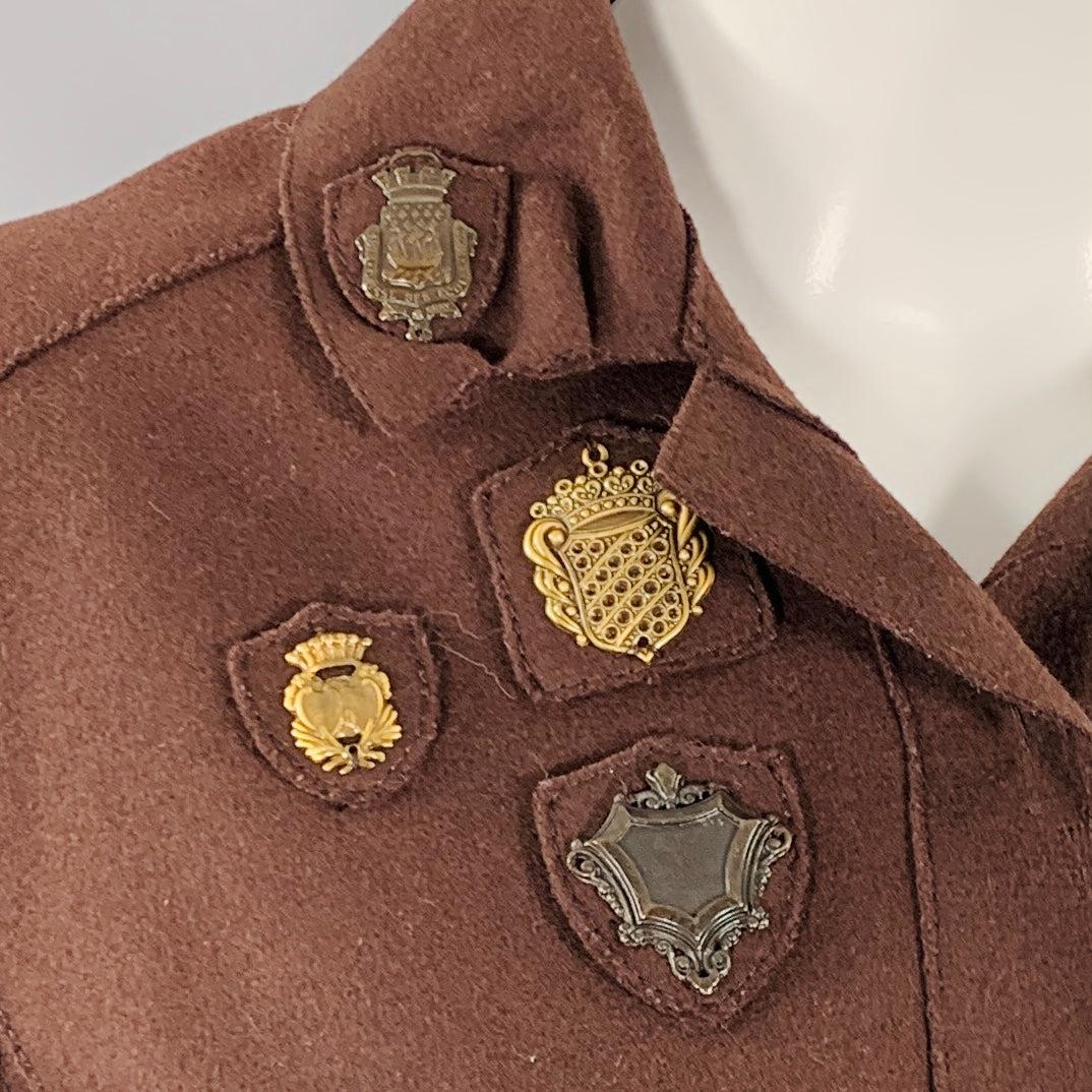 Abito con gonna MIU MIU
in tessuto misto lana e nylon marrone, con una giacca monopetto con toppe in metallo color ottone e una gonna a portafoglio plissettata abbinata con chiusura a fibbia in metallo color ottone. Made in Italy.Ottime condizioni
