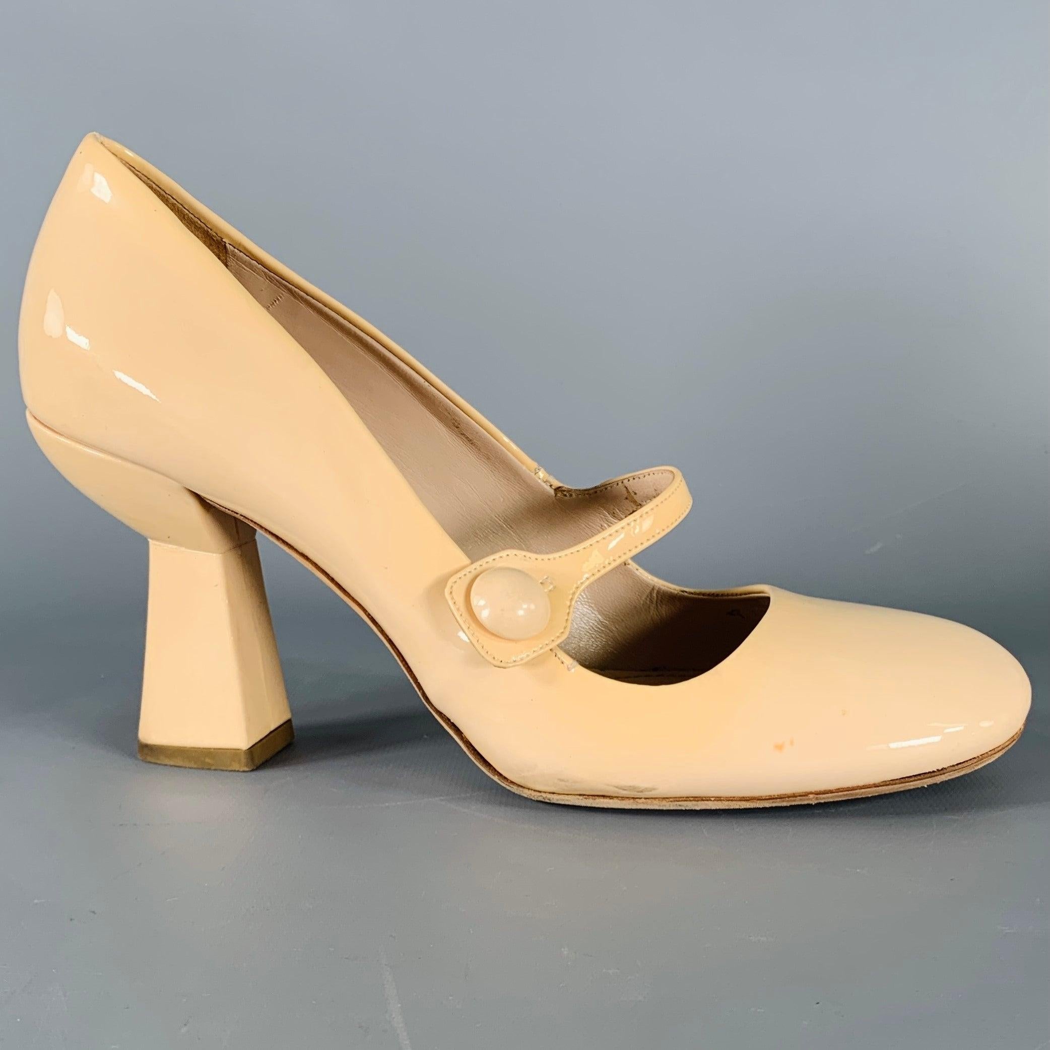MIU MIU pumps
in a nude patent leather fabric featuring a Mary Jane style, chunky heel, and slip on closure. Comes with box. Made in Italy.Very Good Pre-Owned Condition with Box. Moderate marks, as is. 

Marked:   38 

Measurements: 
  Heel: 3.5