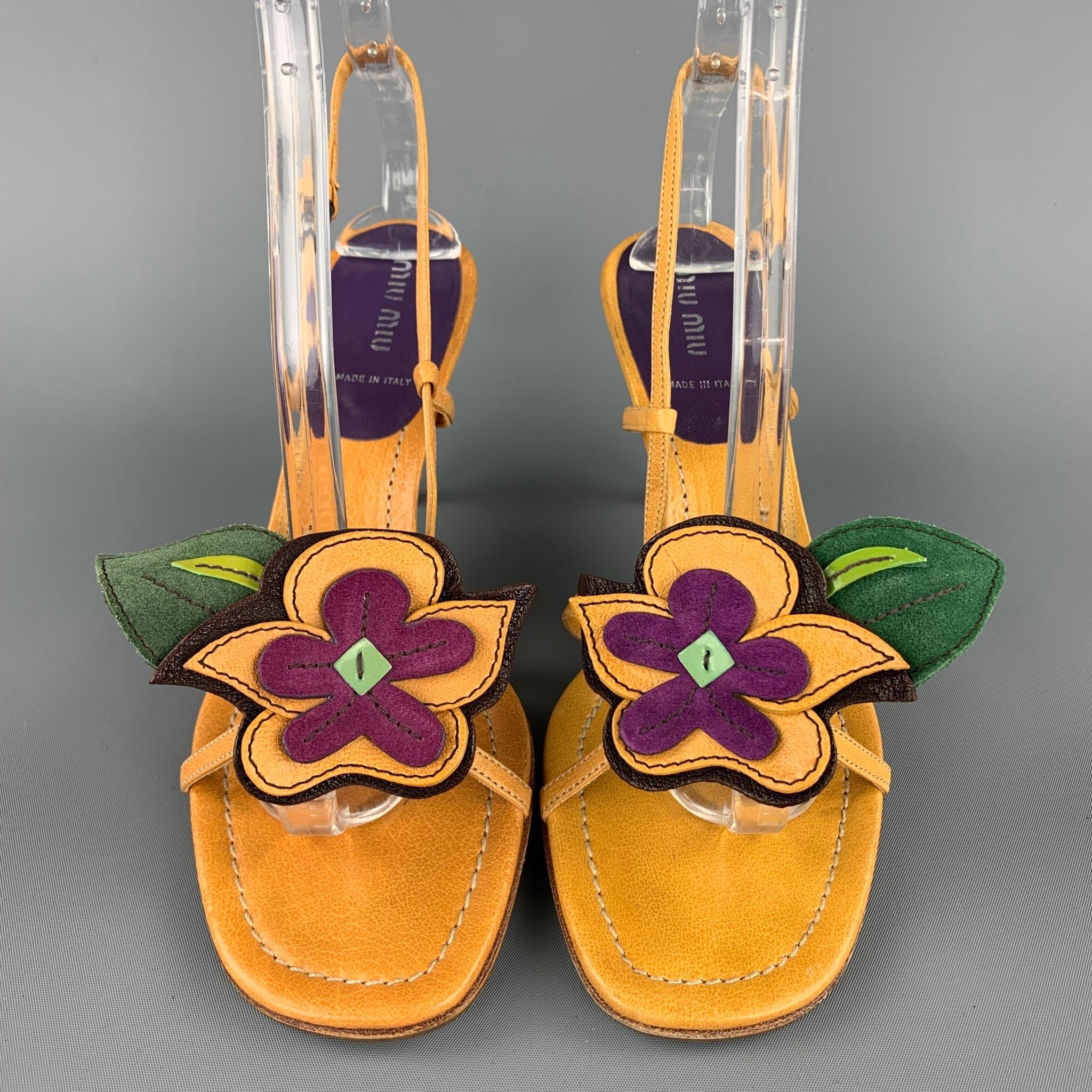 I sandali MIU MIU sono in pelle color senape con un'applicazione di fiori viola, hanno la parte posteriore e il tacco viola. Prodotto in Italia.

Ottimo stato usato.
Marcato: EU 38

Misure:

Tacco: 3,25 pollici.