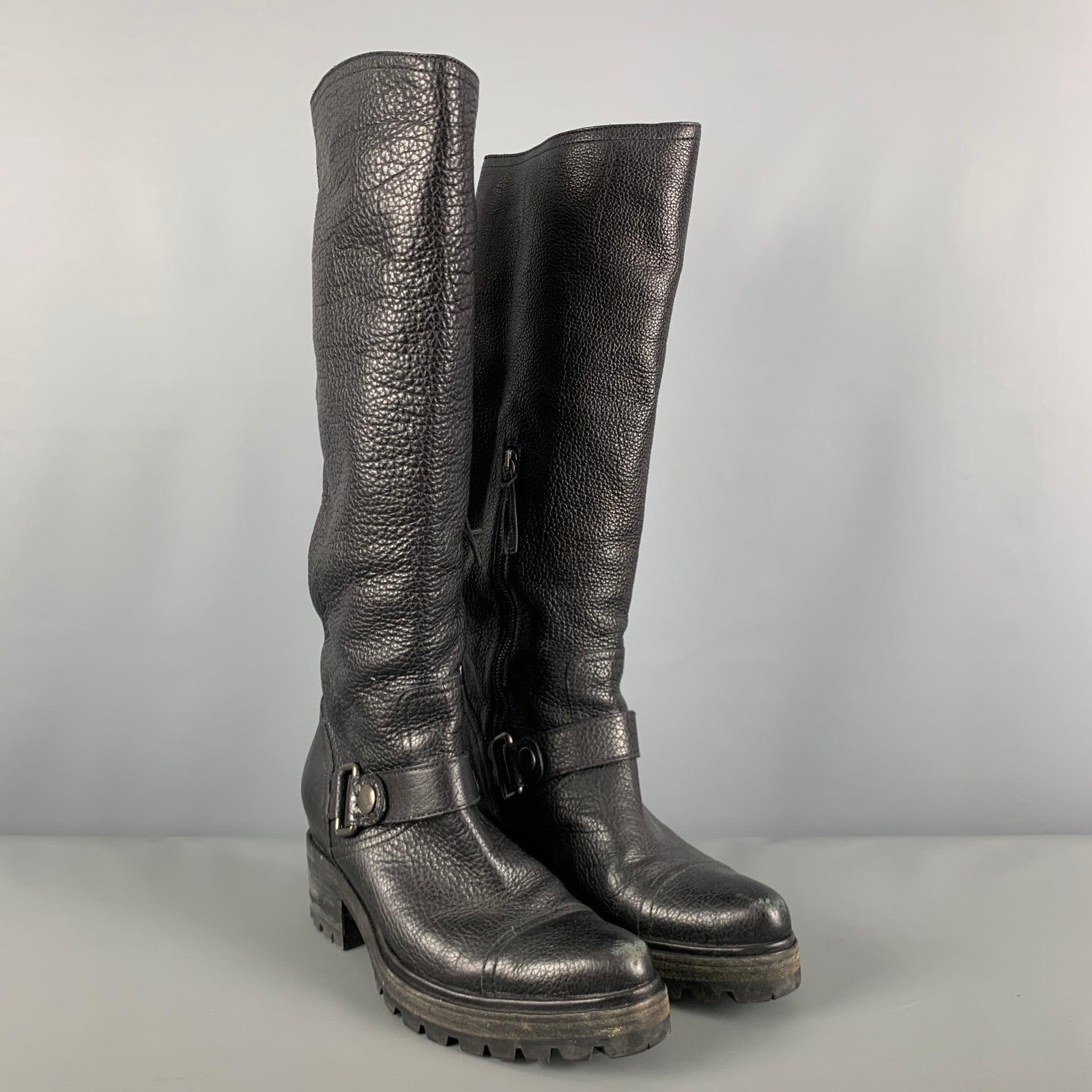 MIU MIU boots comes in a black pebble grain leather featuring a mid-calf length, buckle belted details, chunky rubber sole, and a zip up closure. Made in Italy.Excellent Pre-Owned Condition. 

Marked:   39 

Measurements: 
  Length: 11 inches Width: