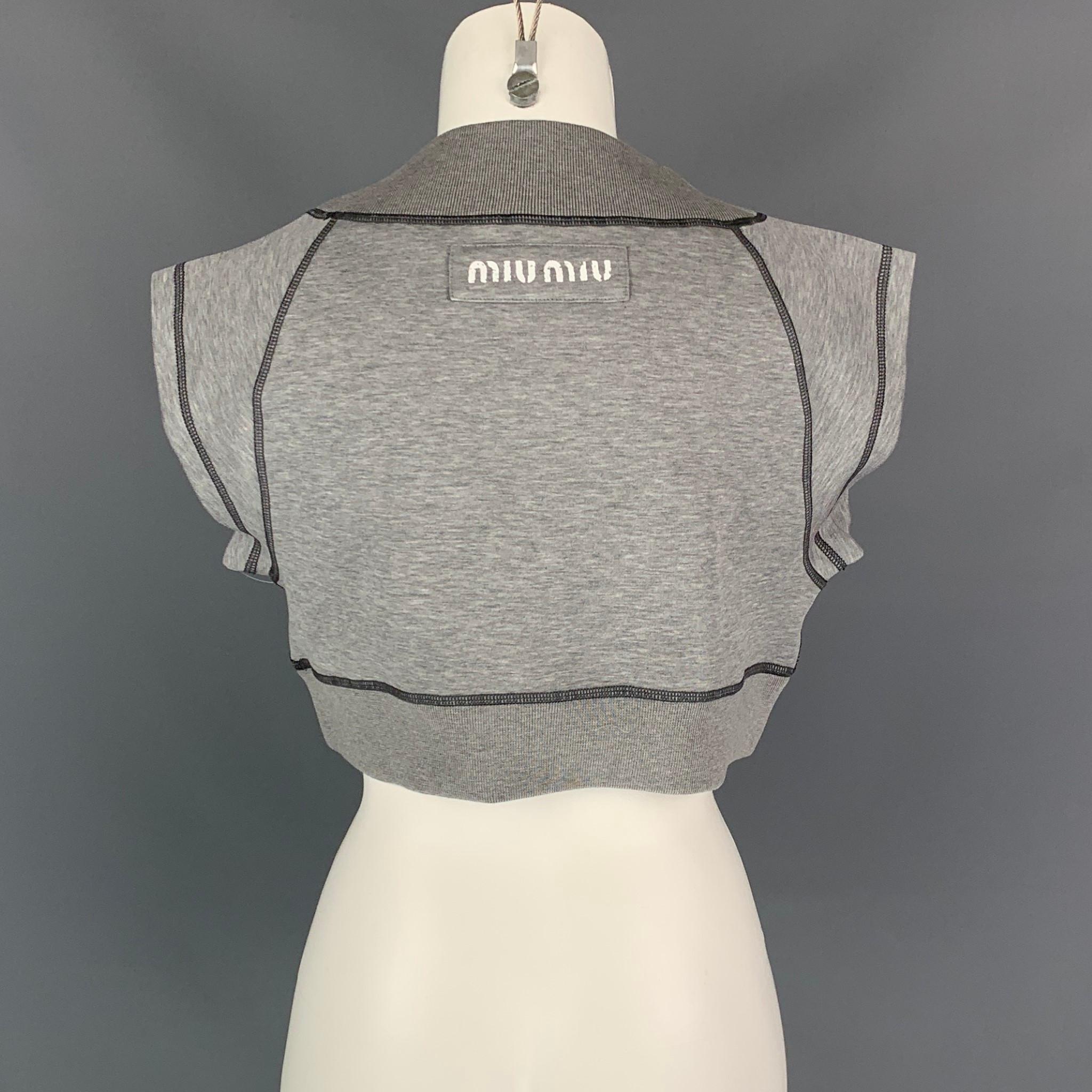 MIU MIU top comes in a gray ribbed cotton featuring a cropped fit, wide collar, logo patch, and contrast stitching. Made in Italy.

Excellent Pre-Owned Condition.
Marked: XS
Original Retail Price: $1,240.00

Measurements:

Shoulder: 18 in.
Bust: 38