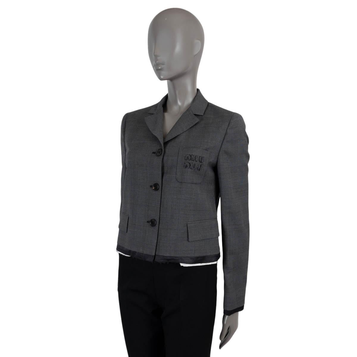 100% authentic Miu Miu cropped blazer in dark grey wool (100%). Features a boxy silhouette, raw hem, notch lapels, two flap pockets at the waist and a logo embroidered patch pocket at the chest. Closes with buttons on the front and is lined in