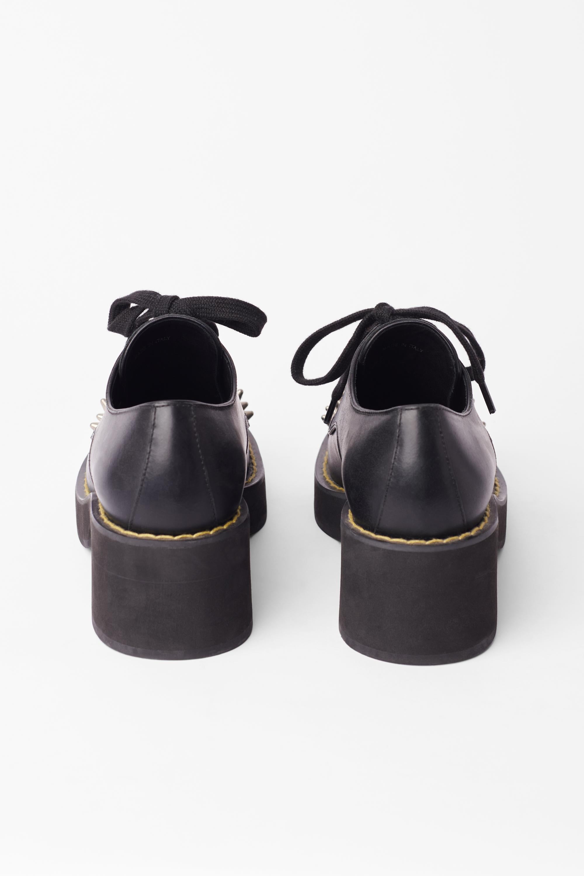 Miu Miu spiked leather shoes. Features lace up with four eyelets, silver spiked front, yellow contrast stitching and 2 inch block heel. In excellent condition, brand new with original box
Brand: Miu Miu
Size: UK 3
Color: Black
Tag Size: EU 36
Modern