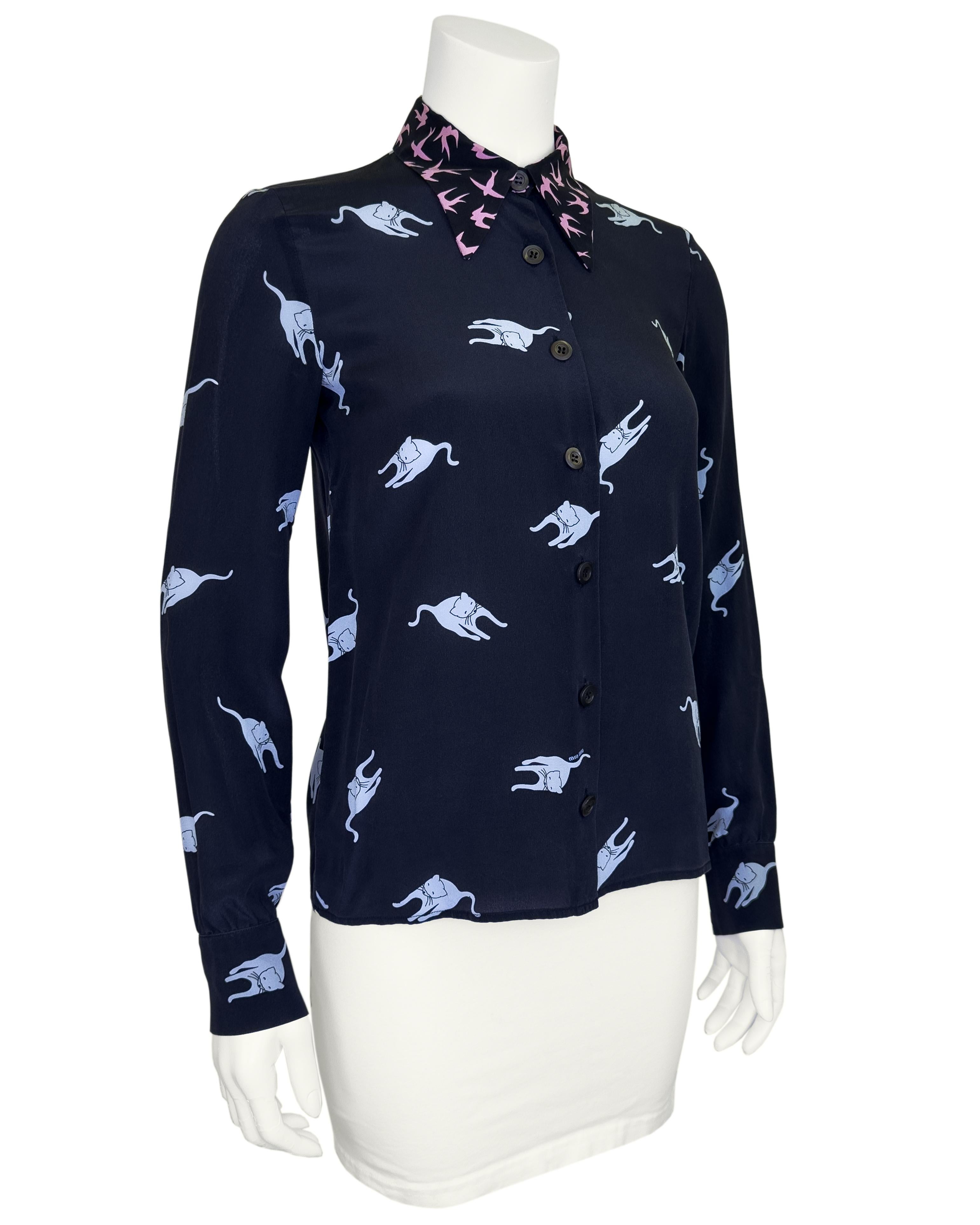 As seen on the SS 2010 runway, this whimsical silk blouse by Miu Miu is for the modern fashion lover who has an enthusiasm for the feline-kind! Featuring luxurious silk in inky blue, all over print with cats and swallow birds on collar in